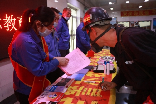 图为东荣二矿安全协管员现场向职工讲解安全警示教育月活动的意义和目的